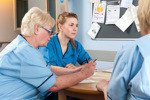 Three nurses sitting round a desk talking