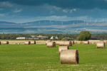 A view of rural Scotland with hay bales and hills in the distance