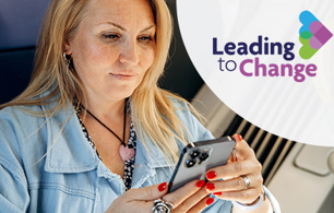 Woman seated on a train using a smartphone, with part of the train interior and a seat visible in the background. The leading to change logo is positioned on the right of the image.