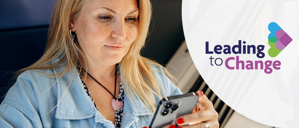 Woman seated on a train using a smartphone, with part of the train interior and a seat visible in the background. The leading to change logo is positioned on the right of the image.