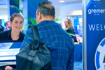 Conference registration area with attendees at a desk and a large blue sign reading ‘WELCOME TO P4H SCOTLAND’, alongside logos for Greiner Bio‑One, 40BiP and NHS National Services Scotland.