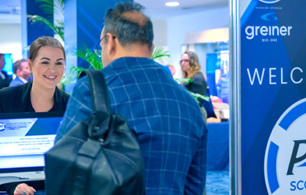 Conference registration area with attendees at a desk and a large blue sign reading ‘WELCOME TO P4H SCOTLAND’, alongside logos for Greiner Bio‑One, 40BiP and NHS National Services Scotland.